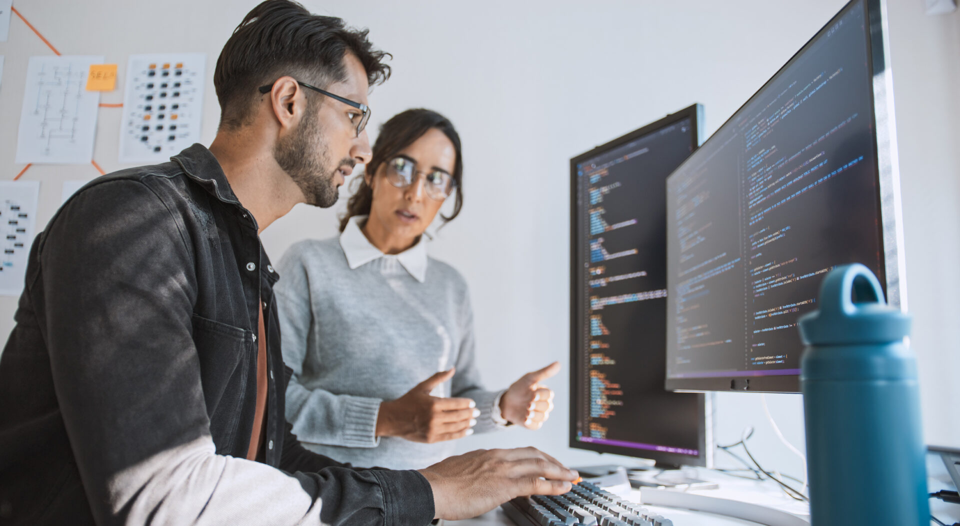 Two people collaborating at computer screens.